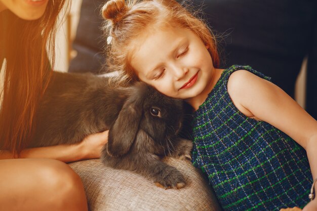 madre con estilo con cabello largo y un vestido verde jugando con su pequeña hija linda