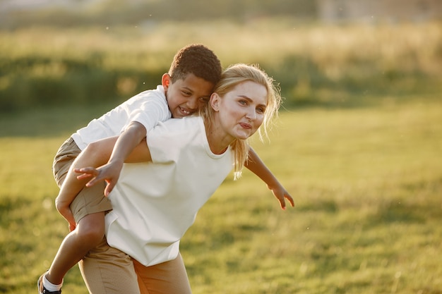 Foto gratuita madre europea e hijo africano. familia en un parque de verano.