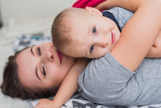 Foto gratuita madre feliz descansando con su hijo