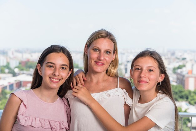 Madre feliz y dos hijas abrazándose