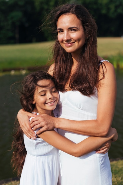 Madre feliz e hija abrazando al aire libre