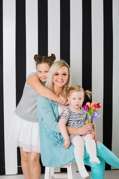 Foto gratuita madre feliz con hijas y ramo de flores.