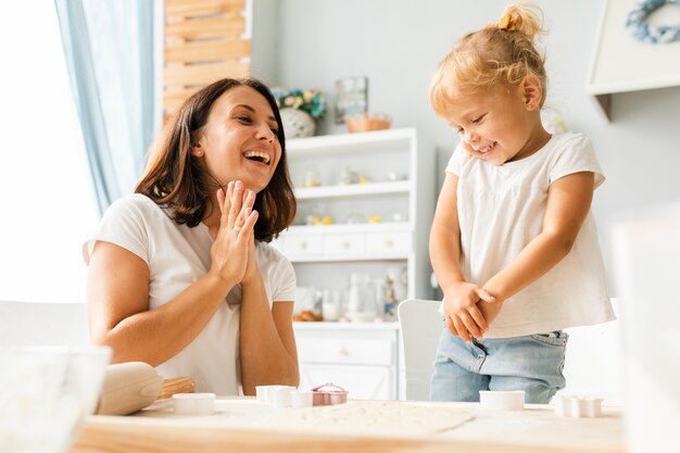 Madre feliz que mira a la niña linda