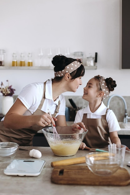 madre feliz con su niña cocinando en casa