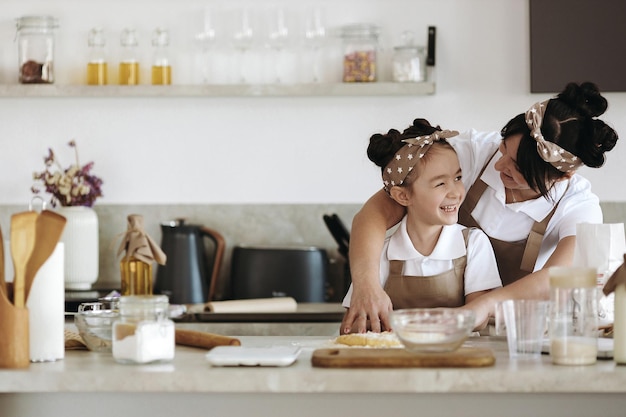 madre feliz con su niña cocinando en casa