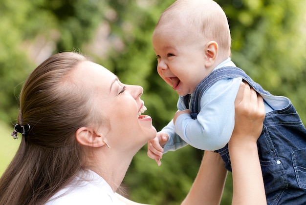 Madre feliz con su pequeño hijo lindo