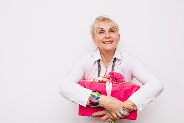 Madre feliz sujetando caja de regalo rosa