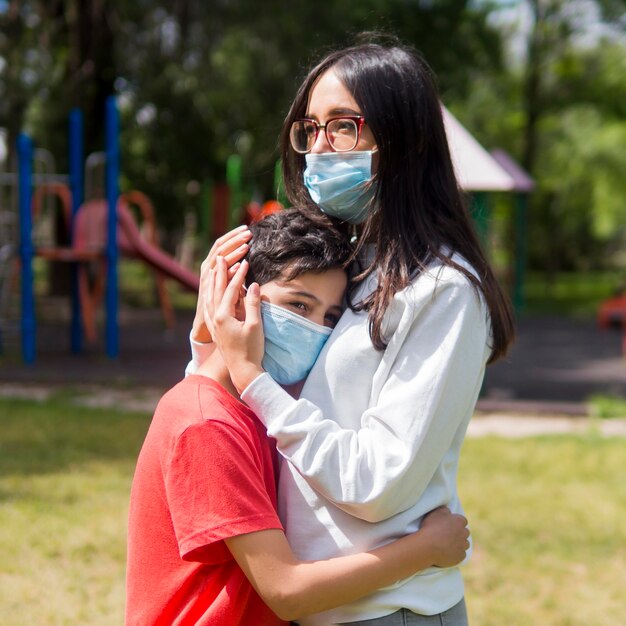 Madre con gafas de lectura abrazando a su hijo