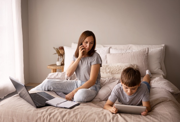 Foto gratuita madre hablando por teléfono plano completo