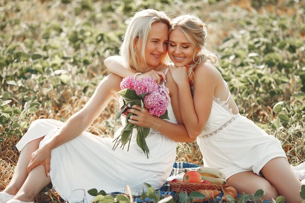 Madre con hermosa hija en un campo de otoño