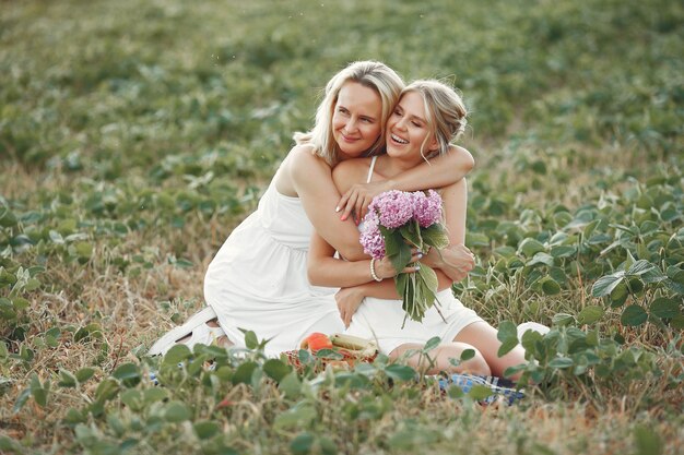 Madre con hermosa hija en un campo de otoño