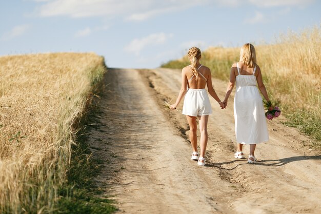 Madre con hermosa hija en un campo de otoño