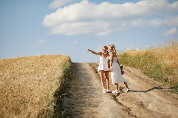 Madre con hermosa hija en un campo de otoño