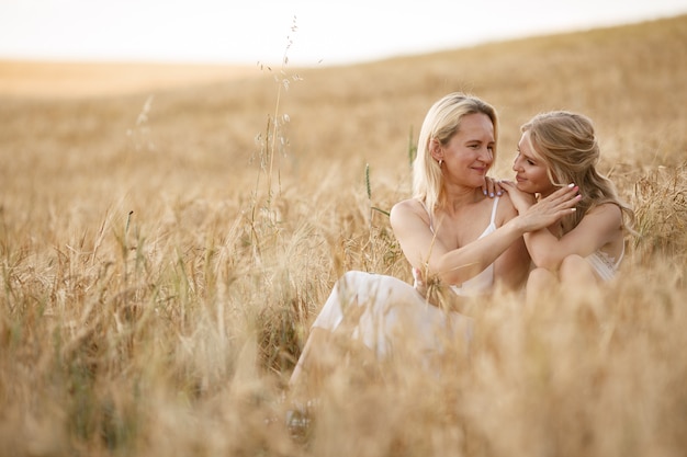 Madre con hermosa hija en un campo de otoño