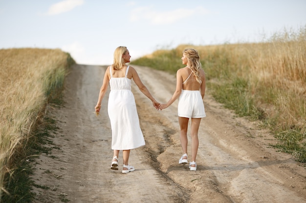 Madre con hermosa hija en un campo de otoño