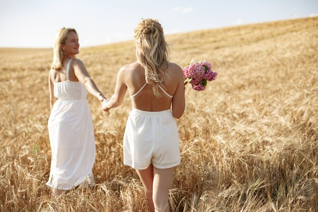 Madre con hermosa hija en un campo de otoño