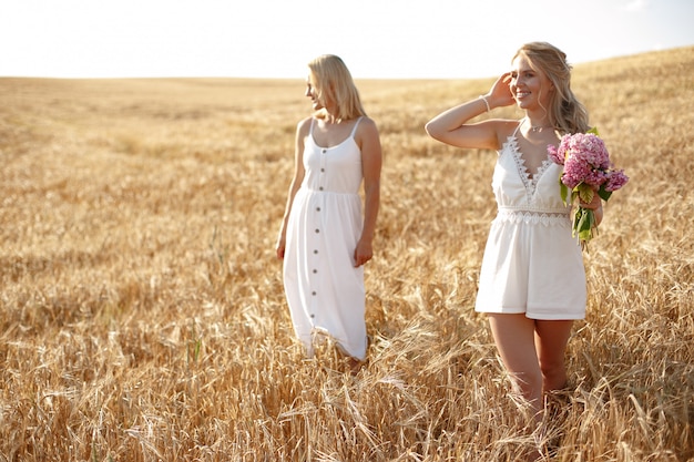 Madre con hermosa hija en un campo de otoño