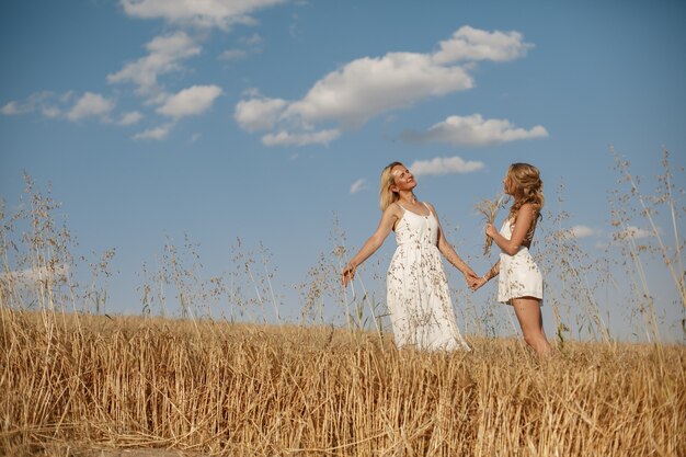 Madre con hermosa hija en un campo de otoño