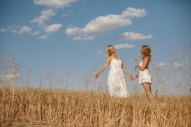 Madre con hermosa hija en un campo de otoño