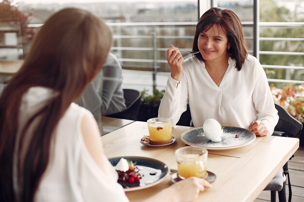 Madre con hija adulta sentada en un café