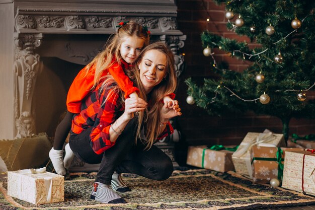 Madre con hija por arbol de navidad