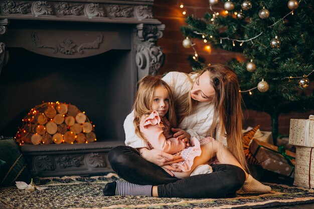 Madre con hija por arbol de navidad