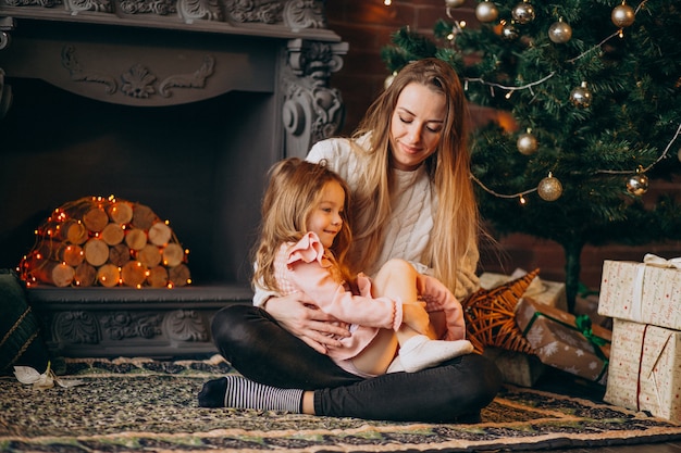 Madre con hija por arbol de navidad