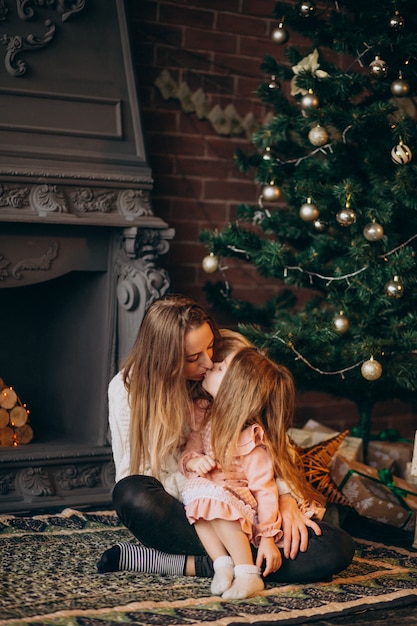 Madre con hija por arbol de navidad