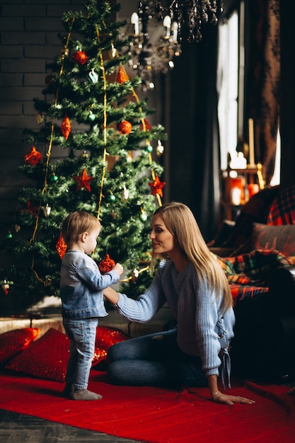 Madre con hija por arbol de navidad