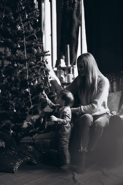 Madre con hija por arbol de navidad