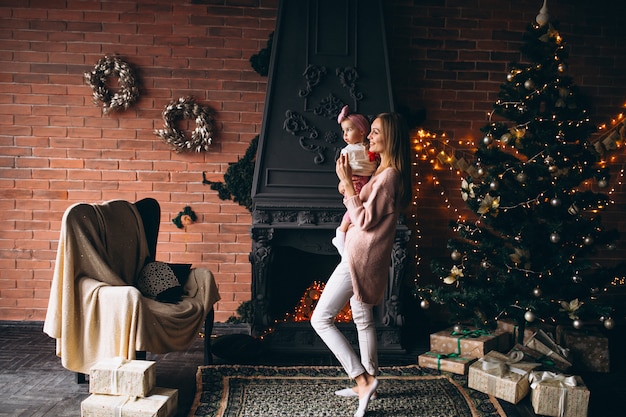 Madre con hija por arbol de navidad