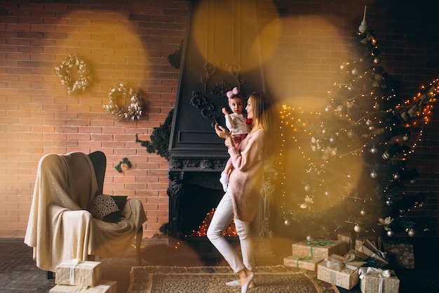 Madre con hija por arbol de navidad