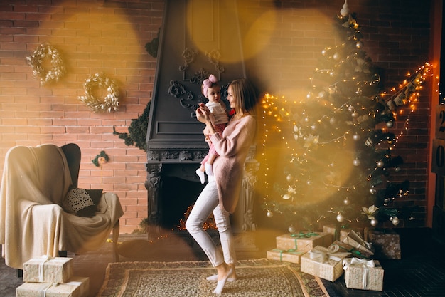 Madre con hija por arbol de navidad