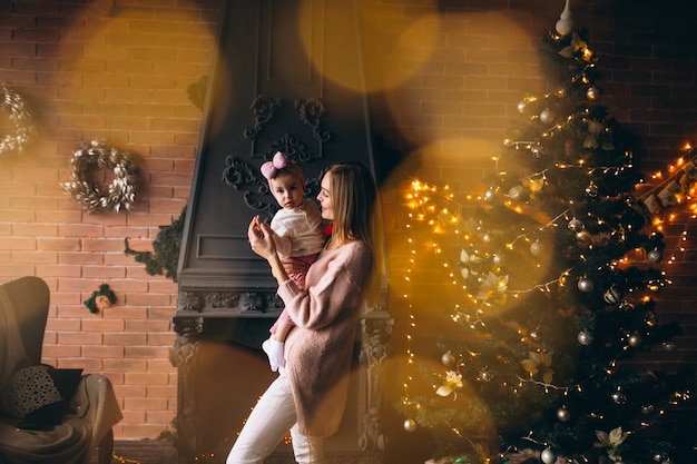 Madre con hija por arbol de navidad