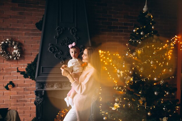 Madre con hija por arbol de navidad