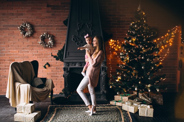 Madre con hija por arbol de navidad