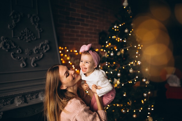 Madre con hija por arbol de navidad