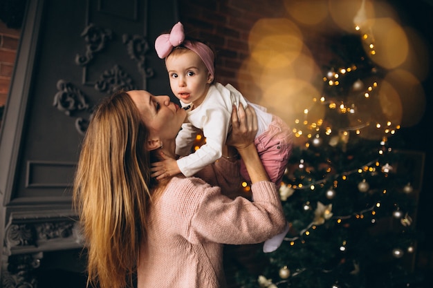 Madre con hija por arbol de navidad