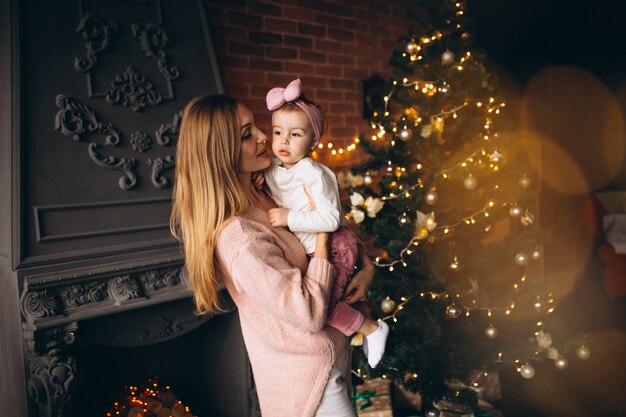 Madre con hija por arbol de navidad