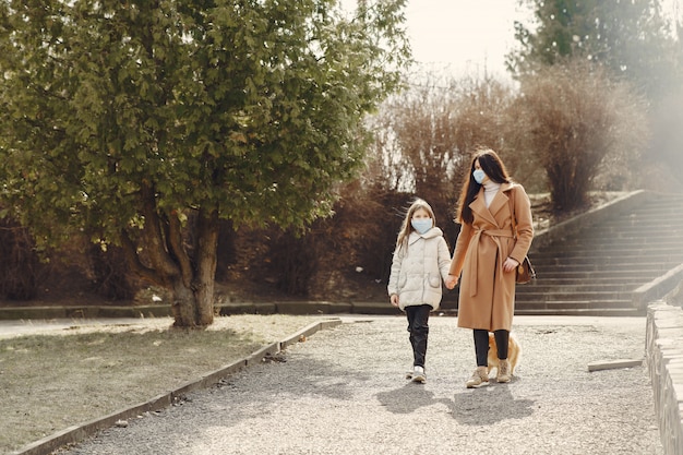 Foto gratuita madre con hija camina afuera en máscaras