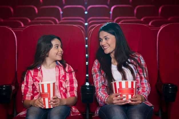 Foto gratuita madre con hija en el cine