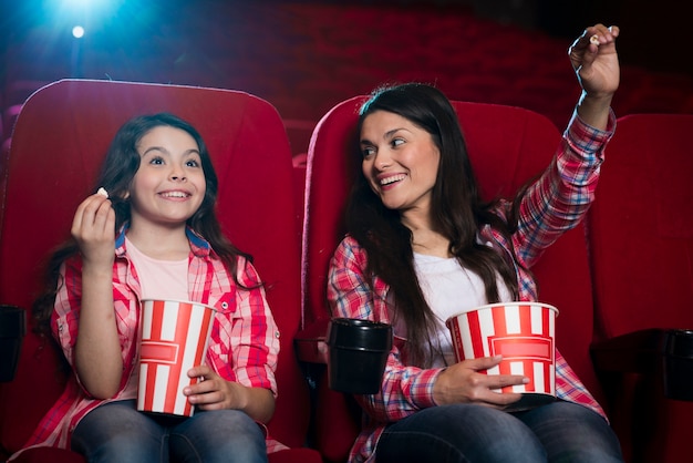 Foto gratuita madre con hija en el cine