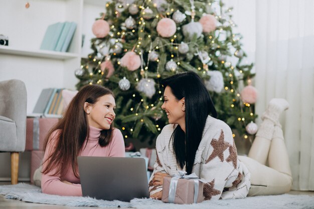 Madre con hija de compras en línea en navidad
