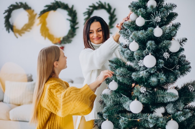 Madre con hija decorando el árbol de navidad