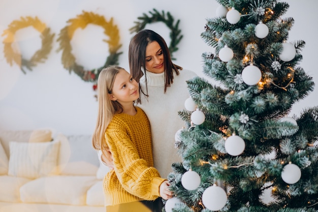 Madre con hija decorando el árbol de navidad