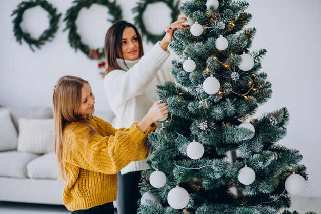 Madre con hija decorando el árbol de navidad