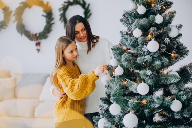 Madre con hija decorando el árbol de navidad