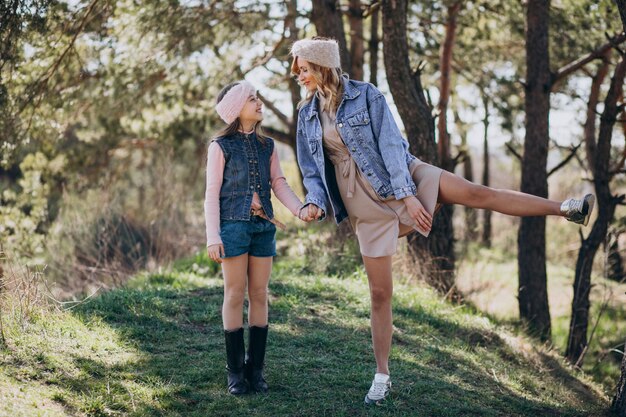 Madre con hija divirtiéndose en el bosque