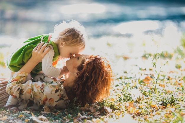 Foto gratuita la madre y la hija se encuentran en la hierba