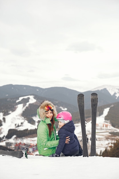 Madre con hija esquiando. Gente en las montañas nevadas.